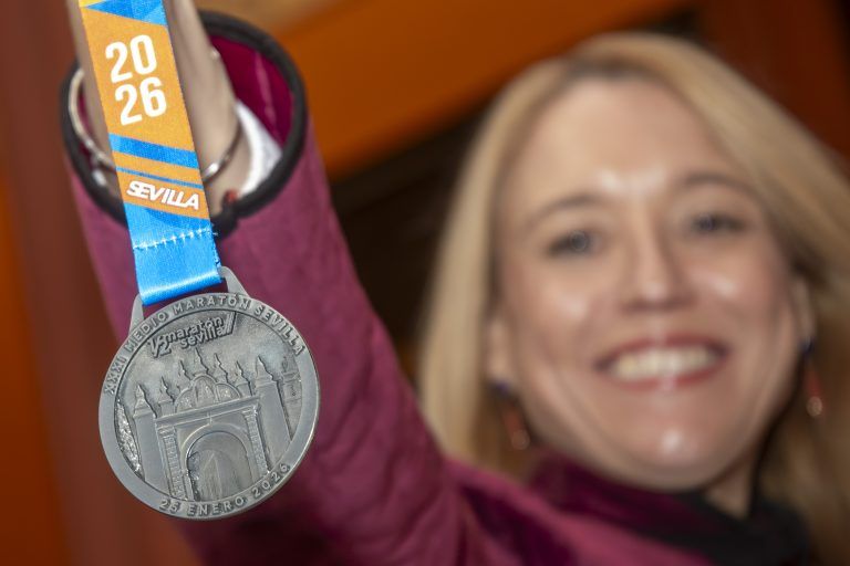 Mar&iacute;a Tena, delegada del IMD, muestra la medalla de la pr&oacute;xima edici&oacute;n de la Media Marat&oacute;n de Sevilla.